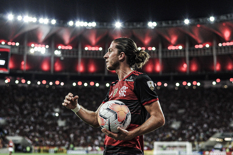 Filipe Luís com uniforme do Flamengo segurando a bola no Maracanã lotado