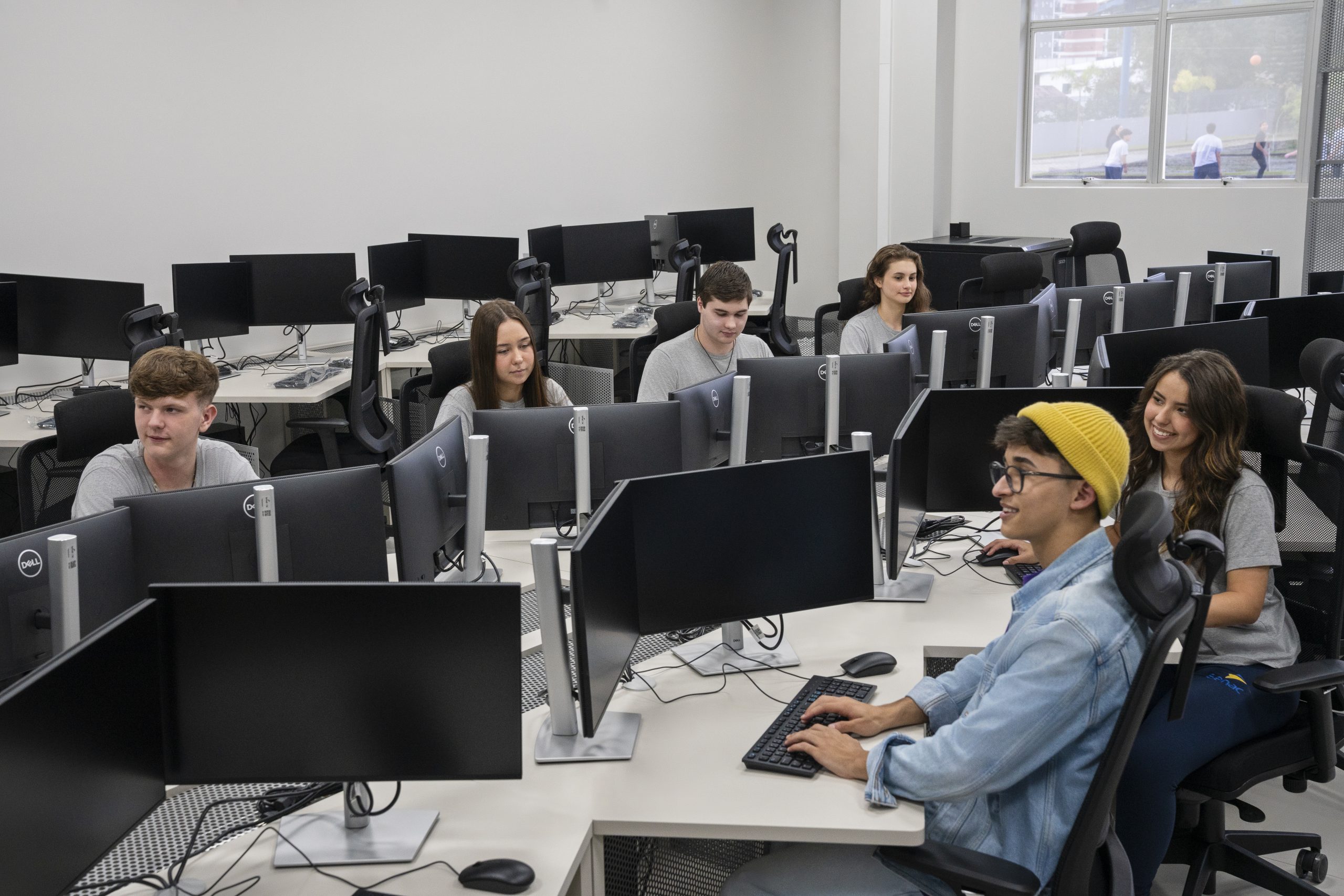 Estudantes do Senac Jaraguá do Sul usam computadores em sala de aula moderna