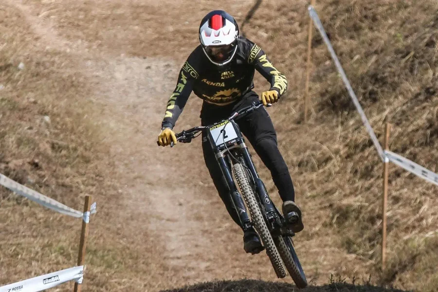 Atleta de downhill desce trilha íngreme durante competição em Pomerode