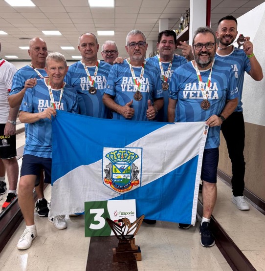 Equipe de bolão 23 de Barra Velha comemora medalha de bronze nos Jasti com bandeira do município