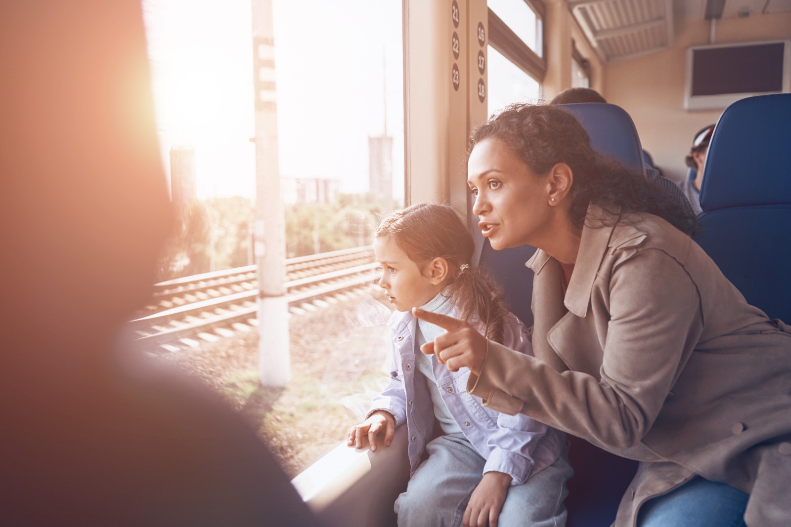 Mãe e filha observam a paisagem pela janela de trem em imagem sobre projeto ferroviário no Norte de Santa Catarina