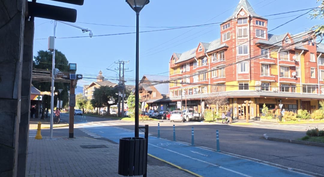 Rua central de Pucón no Chile com ciclovia, prédios e arquitetura típica da cidade