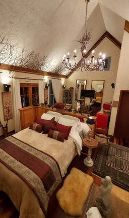Suíte com decoração inspirada na arquitetura francesa em hospedagem do Jardim Secreto Ville de France.