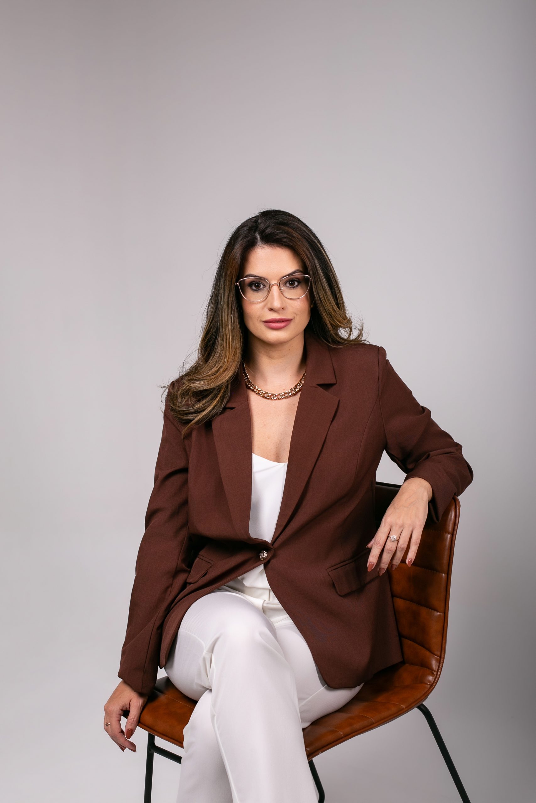 Anamara Dreilich, mentora financeira, posa sentada durante ensaio corporativo sobre planejamento e organização financeira.