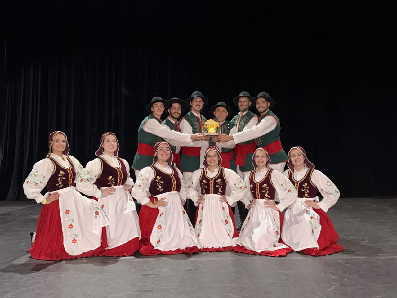 Integrantes do Grupo Folclórico Sünnros exibem troféu conquistado no Festival Catarinense de Danças Populares