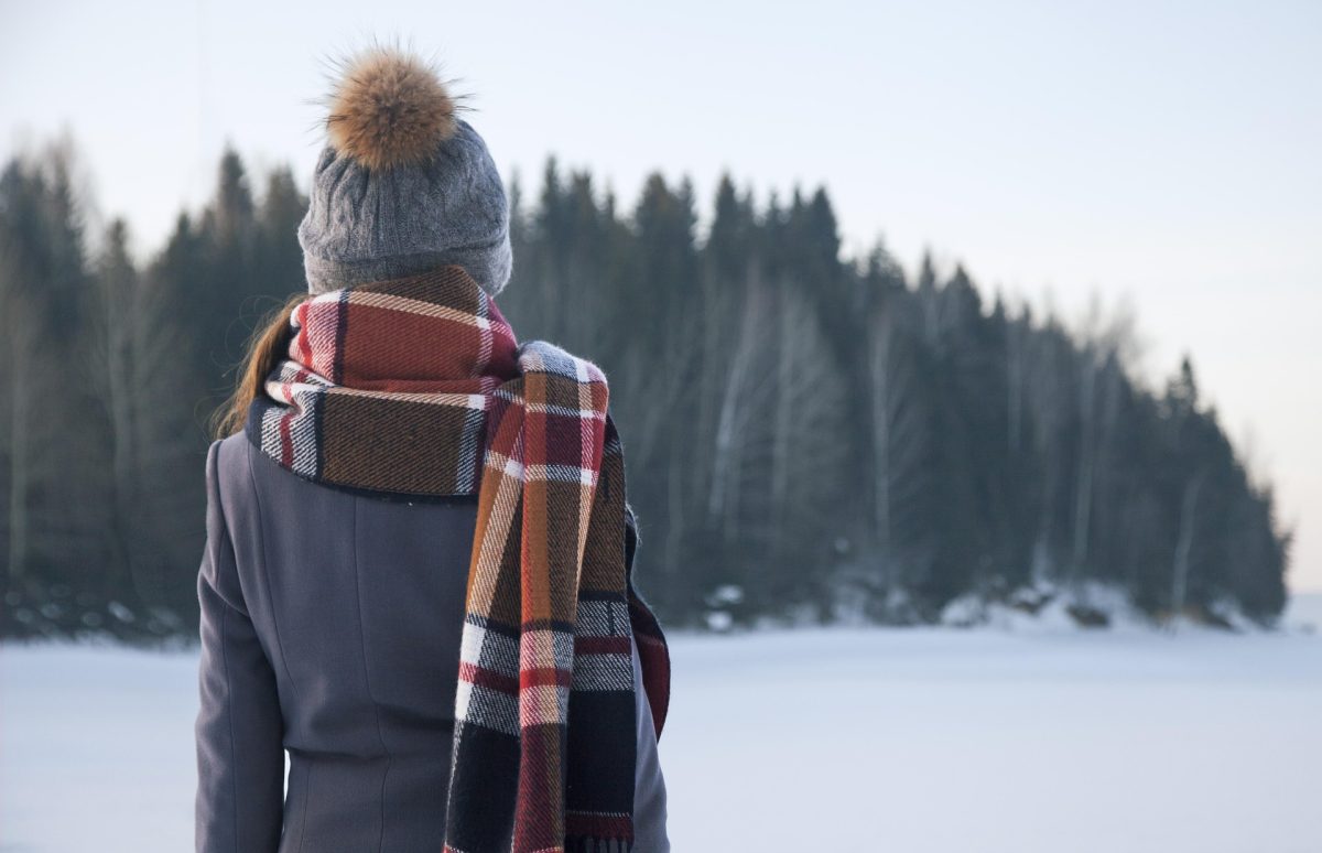 Mulher observando paisagem coberta de neve em cenário que remete à Groenlândia