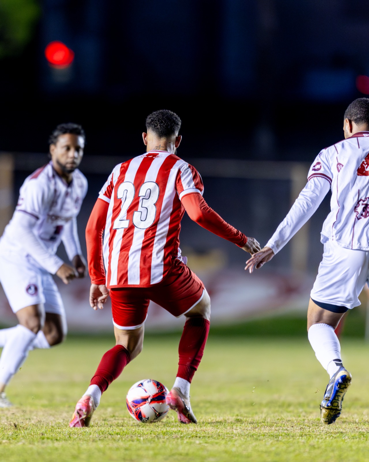 Jogador do Hercílio Luz conduz a bola marcado por atletas do Juventus durante partida da Série B do Campeonato Catarinense, em Tubarão.