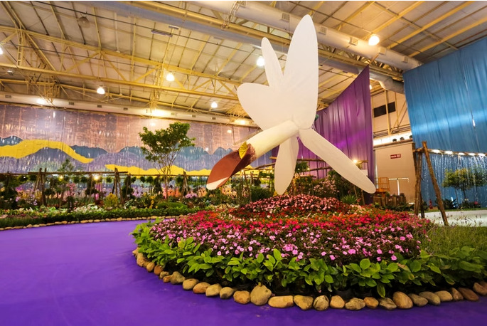 Escultura de orquídea cercada por flores na exposição da Festa das Flores de Joinville