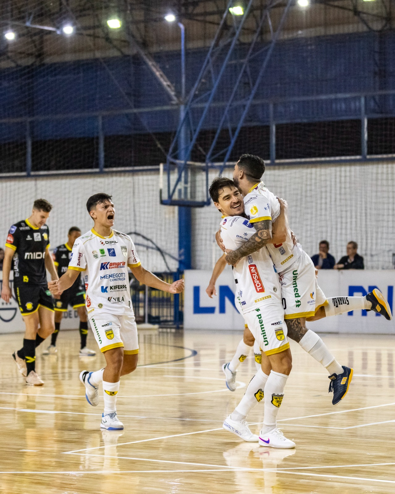 Jogadores do Jaraguá Futsal comemoram gol marcado contra o Praia Clube pela Liga Nacional de Futsal.