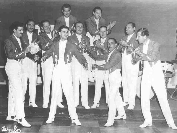 Orquestra de música em trajes claros posa em palco durante baile, em foto antiga ligada ao Salão Doering, em Jaraguá do Sul